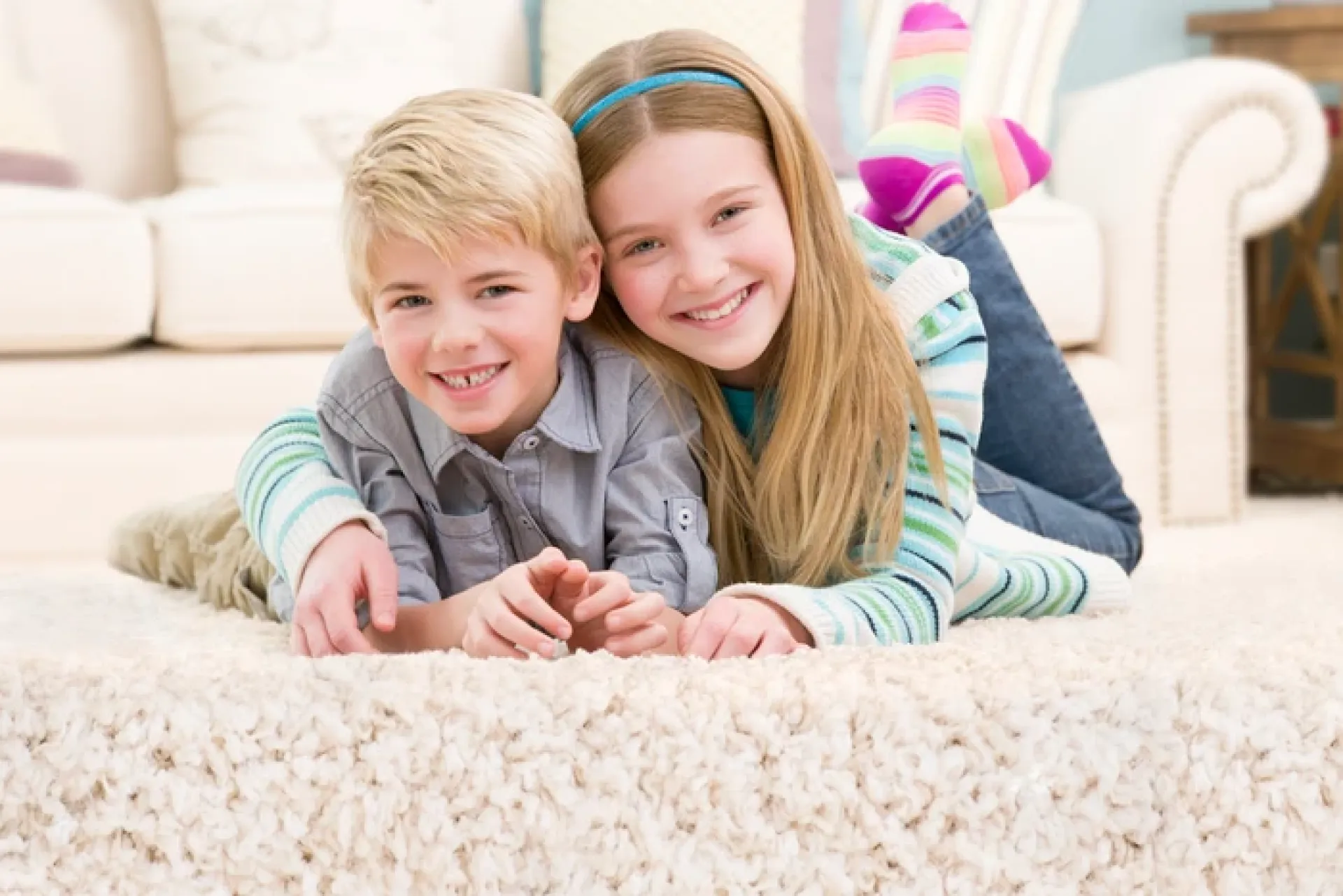 Family bonding time in a cozy bedroom with parents playing with child on the floor.